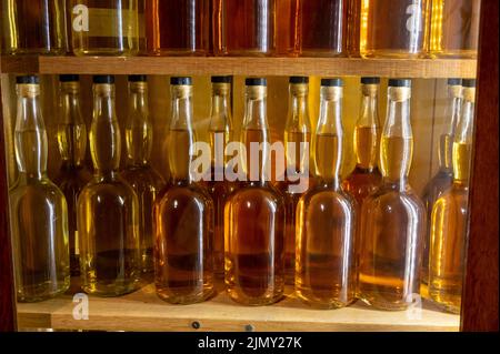 Different ages and colours of strong alcoholic apple drink calvados in Normandy, Calvados region, France, calvados tasting tour Stock Photo