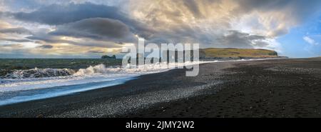 Picturesque autumn Dyrholaey Cape and  rock formations view from Reynisfjara ocean black volcanic sand beach. Vik, South Iceland Stock Photo