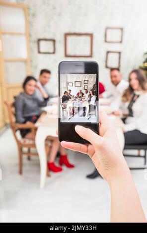 Person taking picture happy family festive table Stock Photo