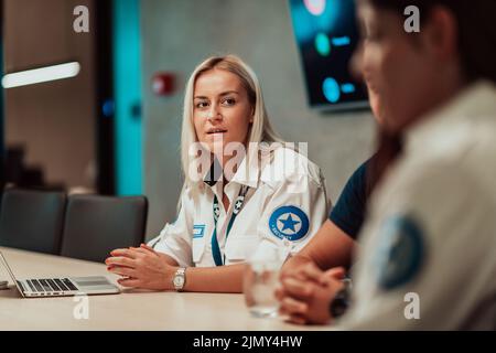 Group of female security operators working in a data system control room Technical Operators Working at workstation with multipl Stock Photo
