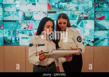 Group of female security operators working in a data system control room Technical Operators Working at workstation with multipl Stock Photo