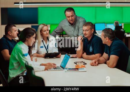 Group of security guards sitting and having briefing In the system control room They're working in security data center surround Stock Photo