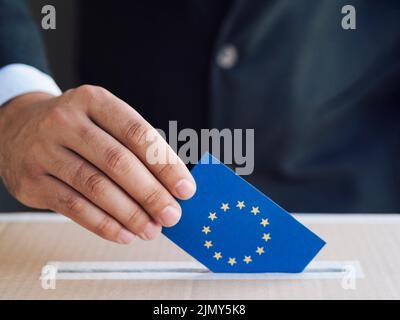 Man putting european election ballot box Stock Photo