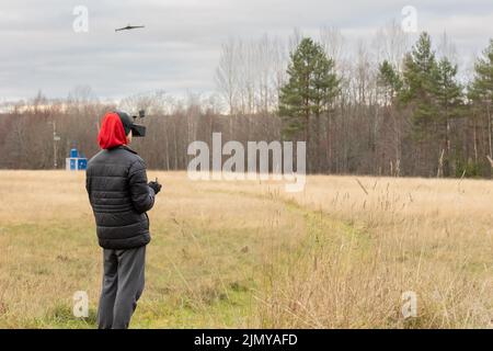 Young man launches rc plane into sky. Teenager with glasses playing with toy radio-controlled airplane outdoors. Boy holding radio remote controller. High quality photo Stock Photo