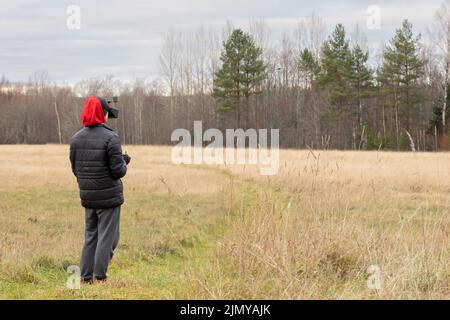 Young man launches rc plane into sky. Teenager with glasses playing with toy radio-controlled airplane outdoors. Boy holding radio remote controller. High quality photo Stock Photo