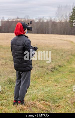 Young man launches rc plane into sky. Teenager with glasses playing with toy radio-controlled airplane outdoors. Boy holding radio remote controller. High quality photo Stock Photo