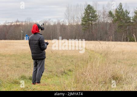 Young man launches rc plane into sky. Teenager with glasses playing with toy radio-controlled airplane outdoors. Boy holding radio remote controller. High quality photo Stock Photo