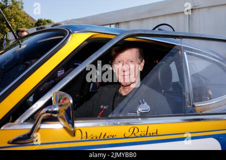 Kiel, Germany. 08th Aug, 2022. Former world rally champion Walter Röhrl sits in his car before the start of the revival of the 1972 Olympic Rally. 197 teams with vehicles from 44 different car brands built between 1950 and 1990 will make their way to Munich in six stages. Credit: Frank Molter/dpa/Alamy Live News Stock Photo