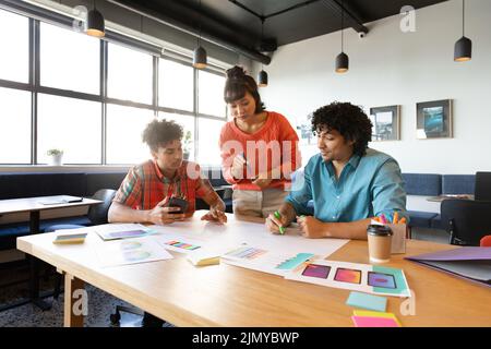Creative multiracial design professionals discussing strategy at table in office Stock Photo