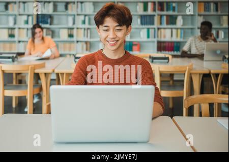 Asian student using laptop in library Stock Photo