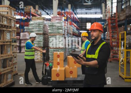 Man portrait happy professional warehouse worker check box stock good package in store worker safety Stock Photo