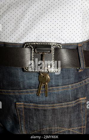 leather key strap with iron carabiner with two keys mounted on a leather belt. Stock Photo