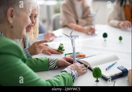 Group of senior students discussing altenrative energy with teacher in classroom, close-up. Stock Photo