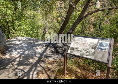 Three Rivers, USA - May 21, 2022: signage and rock with holes for burning fire in prehistoric indian kitchen.. Stock Photo