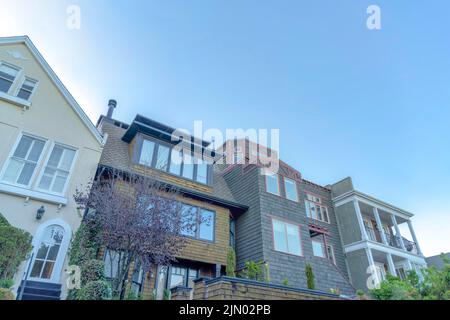 Houses in the suburbs of San Francisco, California. There are house on the left with stairs leading to the arched door, houses in the middle with wood Stock Photo