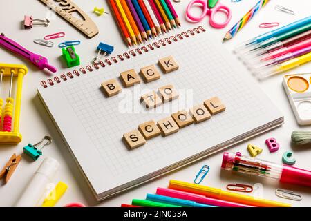 School office supplies and opened notebook on a desk Stock Photo