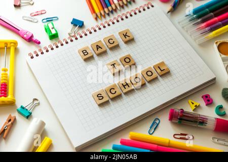School office supplies and opened notebook on a desk Stock Photo
