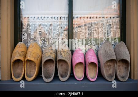Wooden shoes clogs for Dutch family. Walking is historical Dutch fisherman's village in North-Holland, Enkhuizen, Netherlands close up Stock Photo