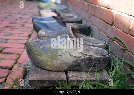 Wooden shoes clogs for Dutch family. Walking is historical Dutch fisherman's village in North-Holland, Enkhuizen, Netherlands close up Stock Photo