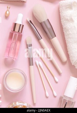 Skin care and make up brushes on light pink, top view. Flat lay with natural beauty products and decorative cosmetics. Everyday woman face care routin Stock Photo