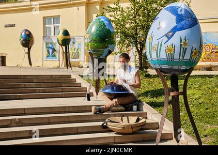 Street music performer playing some unique music with a handcrafted musical instrument called handpan. Stock Photo