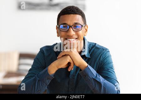Portrait of successful young african american businessman sitting at the workplace in modern office Stock Photo