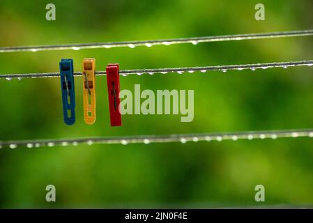 clothing lines of a clothes spin with many raindrops at the string in front of a dark background, after the rain. Retro way of doing the laundry. peg Stock Photo