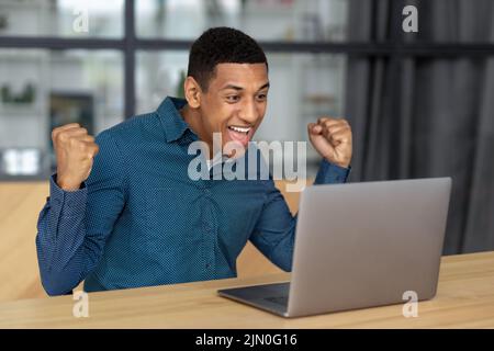 Portrait of excited young African American man celebrating success Happy businessperson male having good news Stock Photo