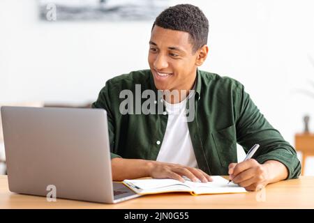 Smiling male student or freelancer studying remotely from home online education e-learning Stock Photo