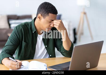 portrait of tired stressed African American man having headache feeling sick Stock Photo