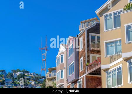 Row of four-storey houses with a view of neighborhood on a mountain slope near the Sutro Tower. View of houses with corner balconies and casement wind Stock Photo