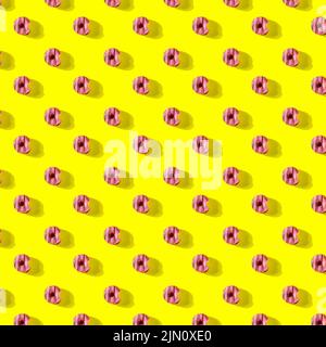 pattern made of Freshly baked donuts  with icing and sprinkles for breakfast on a yellow background . Sweet background. Bakery, baking concept. Stock Photo