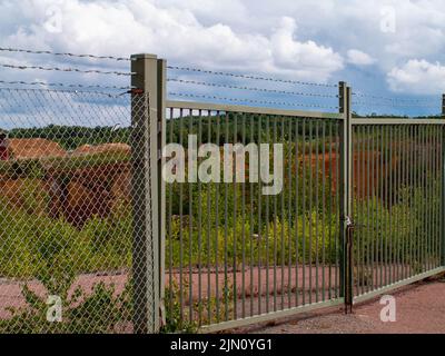 Closed gates at Falun Copper Mine World Heritage with barb wire fence and rusty metallic structure Stock Photo