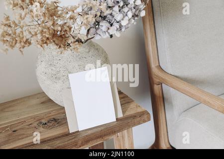 Boho fall still life photo. Rustic vase with dry hydrangea flowers in ceramic vase. Blank horizontal greeting card mockup on old wooden bench. Blurred Stock Photo