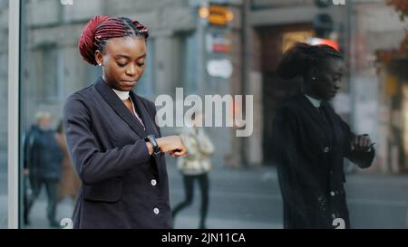 Young business woman african american girl lady walking near building of company office being late for interview meeting moves in street in city Stock Photo