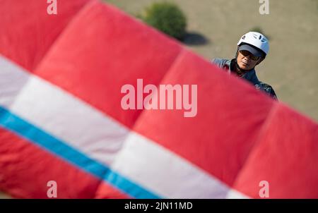 (220808) -- XINJIANG, Aug. 8, 2022 (Xinhua) -- Chen Ruifeng practices paragliding in southern suburb of Urumqi, northwest China's Xinjiang Uygur Autonomous Region, June 11, 2022. Born in Xinjiang, 52-year-old Chen Ruifeng is a paragliding amateur. He says he feels like having his own wings when the paraglider opens. In 2016, Chen Ruifeng started to practice paragliding. Later on, he joined a local club and received his flying certificate after training. As an outdoor enthusiast, he also engages himself in trail running, mountaineering and ice climbing. In his opinions, the unique terrain of Xi Stock Photo