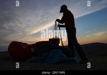 (220808) -- XINJIANG, Aug. 8, 2022 (Xinhua) -- Chen Ruifeng arranges his paraglider in southern suburb of Urumqi, northwest China's Xinjiang Uygur Autonomous Region, June 11, 2022. Born in Xinjiang, 52-year-old Chen Ruifeng is a paragliding amateur. He says he feels like having his own wings when the paraglider opens. In 2016, Chen Ruifeng started to practice paragliding. Later on, he joined a local club and received his flying certificate after training. As an outdoor enthusiast, he also engages himself in trail running, mountaineering and ice climbing. In his opinions, the unique terrain of Stock Photo