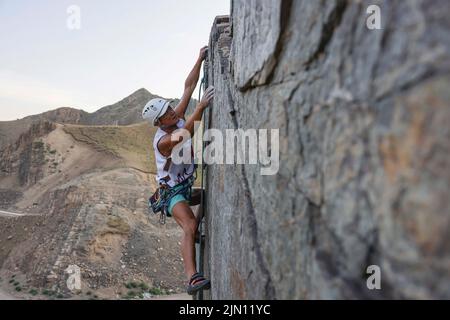 (220808) -- XINJIANG, Aug. 8, 2022 (Xinhua) -- Chen Ruifeng climbs a cliff in eastern suburb of Urumqi, northwest China's Xinjiang Uygur Autonomous Region, May 30, 2022. Born in Xinjiang, 52-year-old Chen Ruifeng is a paragliding amateur. He says he feels like having his own wings when the paraglider opens. In 2016, Chen Ruifeng started to practice paragliding. Later on, he joined a local club and received his flying certificate after training. As an outdoor enthusiast, he also engages himself in trail running, mountaineering and ice climbing. In his opinions, the unique terrain of Xinjiang, s Stock Photo