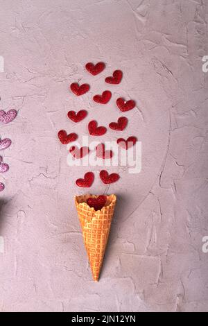 Vertical shot ice cream cone with red hearts. Top view flat lay. Stock Photo