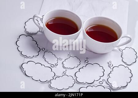 Close up two coffee cups with thought bubbles. Isolated on white. Stock Photo