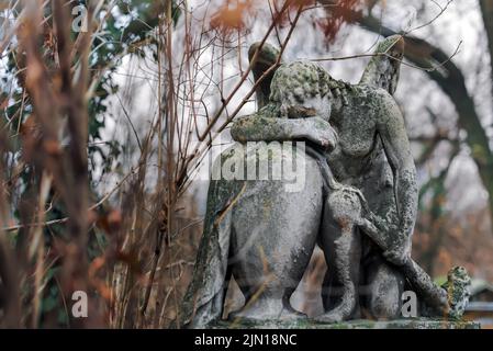 Statue of Grieving Angel in Old European Cemetery Stock Photo