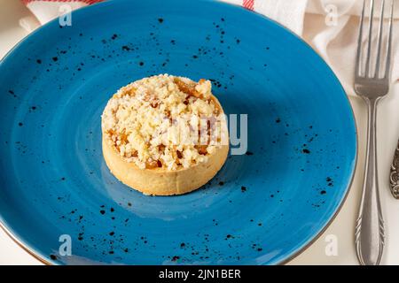 Freshly baked single portion apple pie on a blue porcelain plate Stock Photo