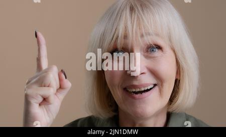 Studio shooting pensive mature old 60s Caucasian woman puzzled thinking planning remind deep in thoughts solves problem concentrate remembers comes up Stock Photo