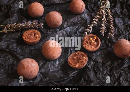 chocolate round candies on dark crumpled craft paper with lavender flowers Stock Photo