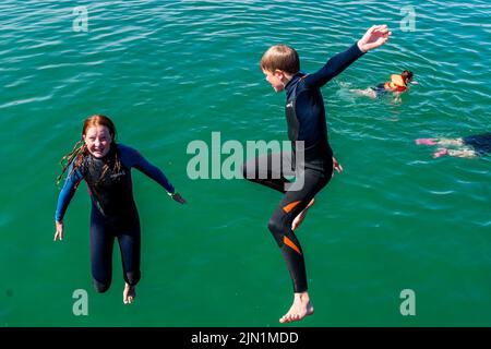 Rosscarbery, West Cork, Ireland. 8th Aug, 2022. Rosscarbery Pier was very busy today with people taking a dip and jumping into the water to cool off on a day with temperatures hitting 21C. Enjoying the sunny weather were Mary and Paddy O'Regan from Clonakilty. Credit: AG News/Alamy Live News Stock Photo