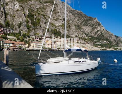 a beautiful old marina in the Italian town of Limone on turquoise lake Garda with mountains in the background (Lombardy) Stock Photo