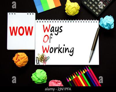 WOW ways of working symbol. Concept words WOW ways of working on white note on a beautiful black background. Black calculator and pen. Business and WO Stock Photo