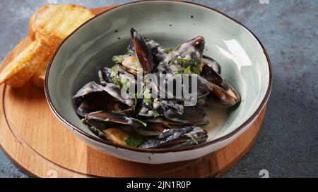 Blue mussels  stewed in cream wine sauce with garlic and herbs. Italian or French traditional food Stock Photo