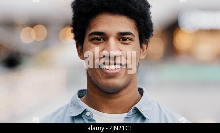Front view portrait male face close-up african millennial man guy looking at camera smiling waving nods head answering yes positive decision agreement Stock Photo