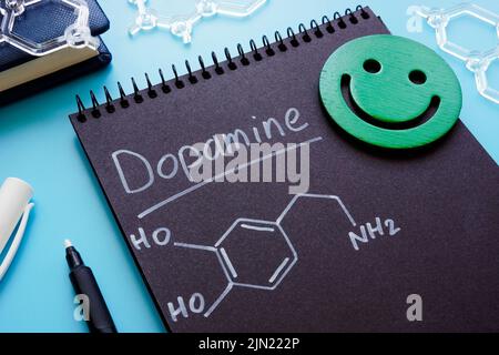 Dopamine chemical formula on the dark page. Stock Photo